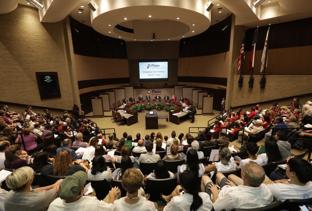Community members listen during a city council meeting at the Plano Municipal Center in...