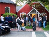 Immigrants gather with their belongings outside St. Andrews Episcopal Church in Edgartown,...
