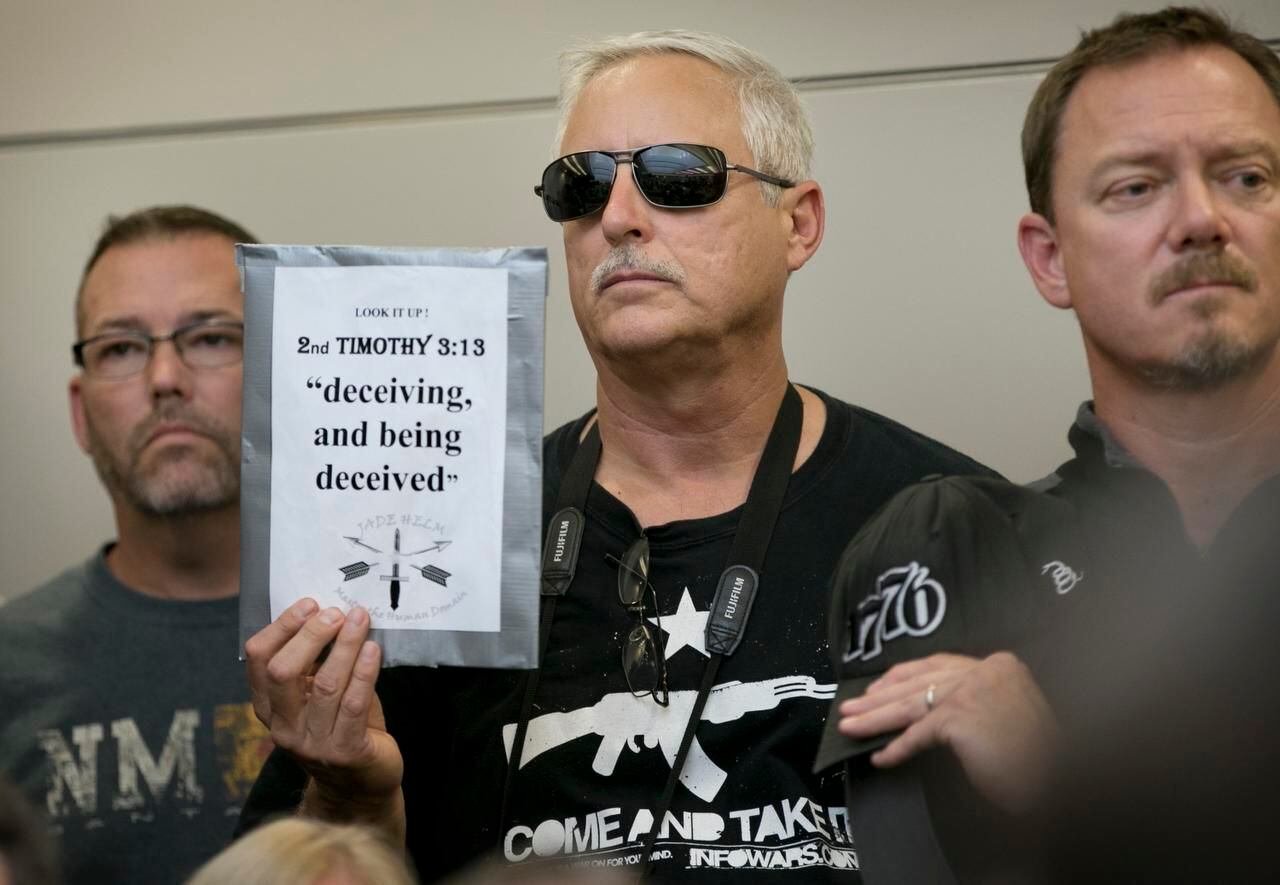 
Bob Welch holds a sign at a public hearing about the Jade Helm 15 military training...