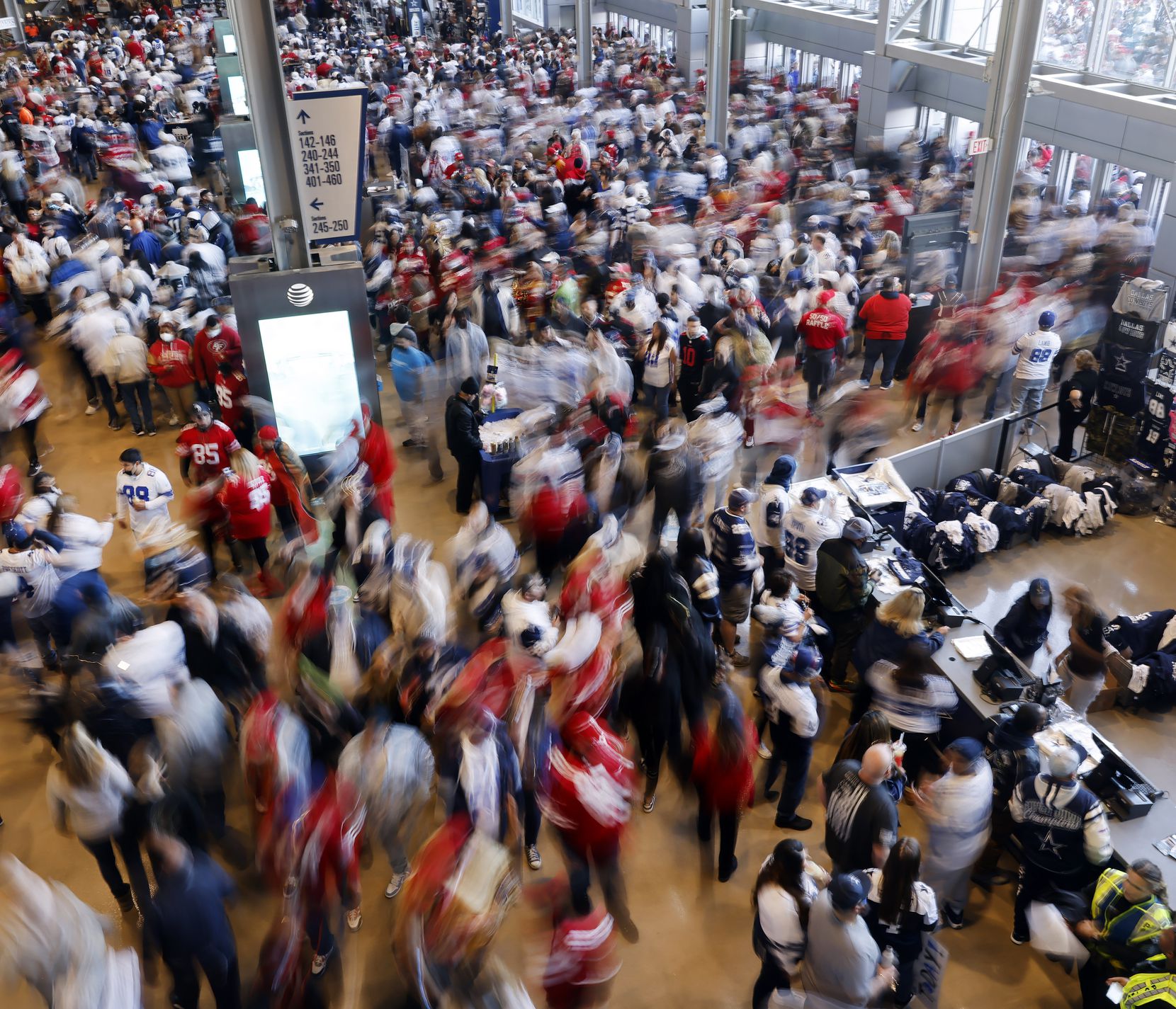 Dallas Cowboys and San Francisco 49ers fans rush through the doors of AT&T Stadium to see...
