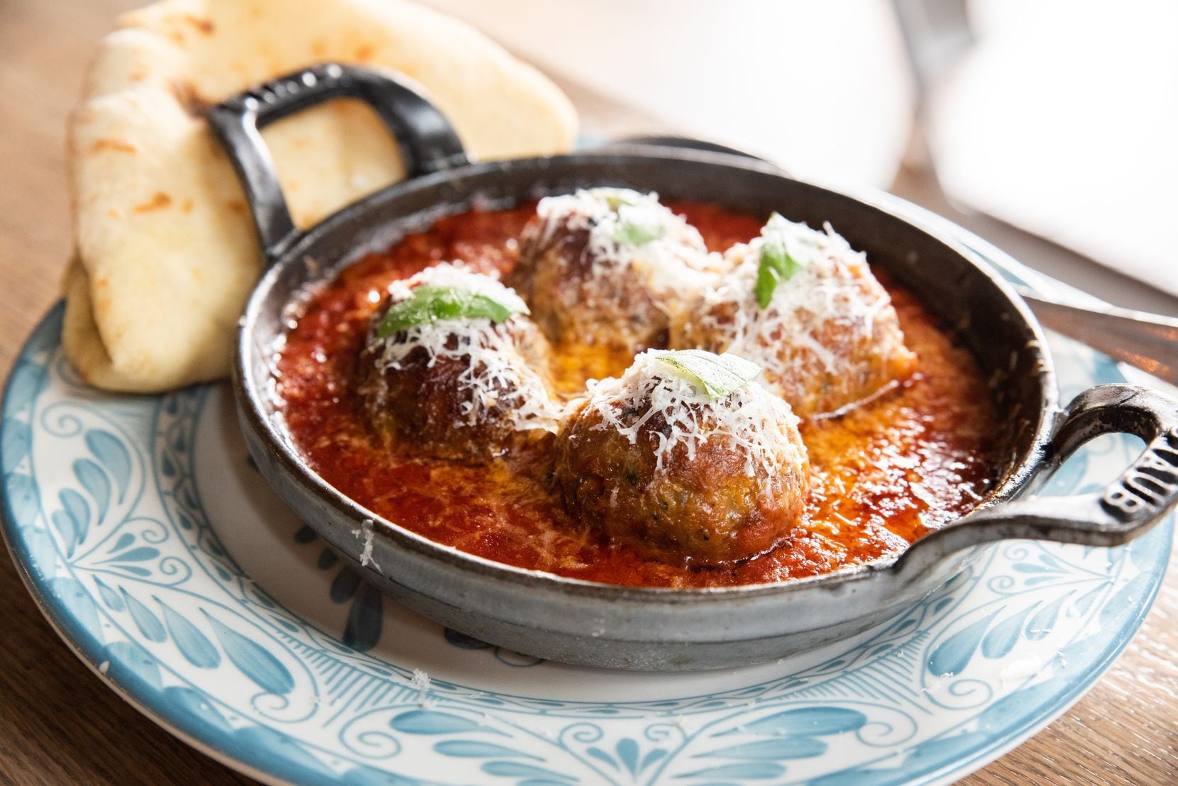 Etta is a restaurant opening in downtown Dallas' East Quarter in 2022, in the same development where Nick Badovinus' newish restaurant National Anthem opened in 2021. The menu includes spicy meatballs with Sunday sauce, pecorino cheese and hearth bread.