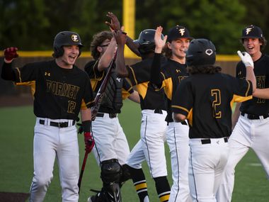 Forney players congratulate their teammates for scoring two runs during a baseball game...