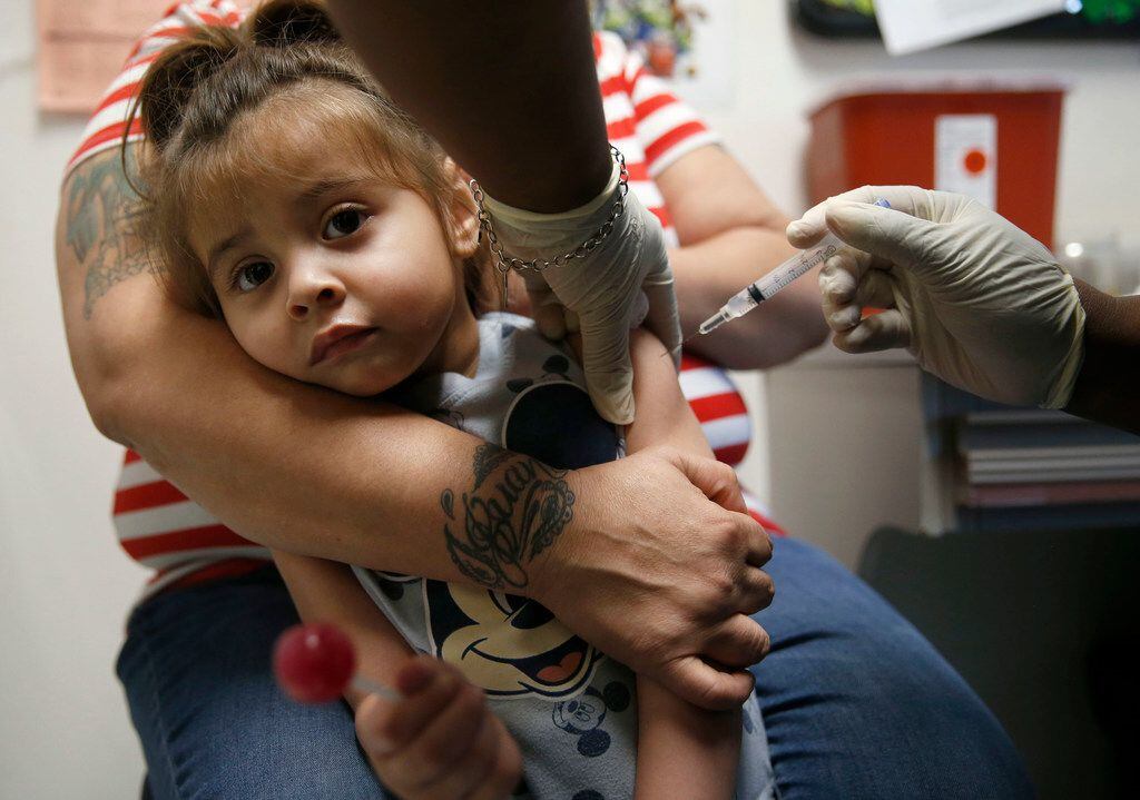 Karma Islas, 2, is held by her mother Maria Islas of Dallas as she gets a shot for a vaccine at the Dallas County Health & Human Services immunization clinic in Dallas on Friday, March 8, 2019.