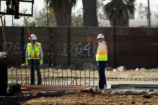 Unos equipos de construcción trabajan en unos prototipos para un muro que separará Tijuana,...