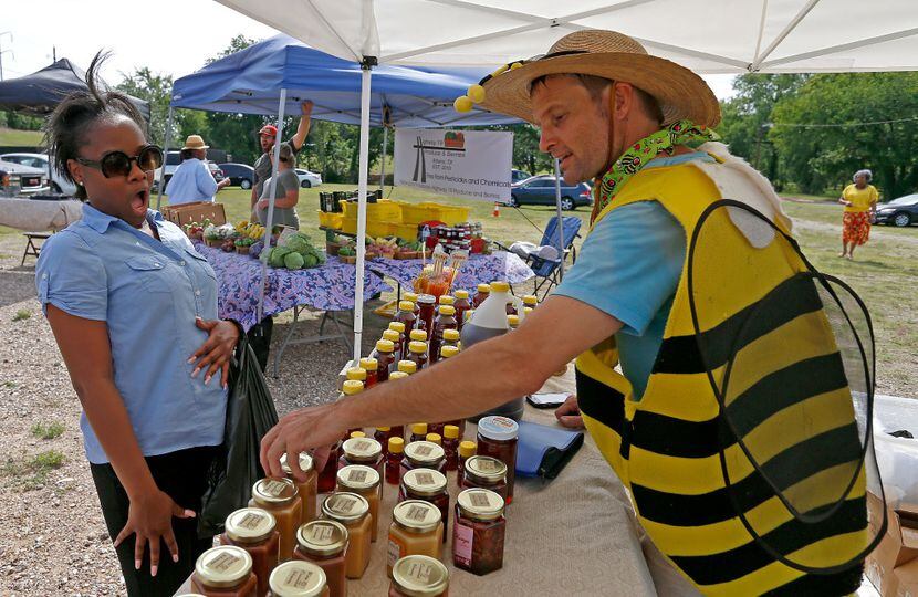 Brandon Pollard (right) talks with Natalie Steward about honey products at Texas Honeybee...