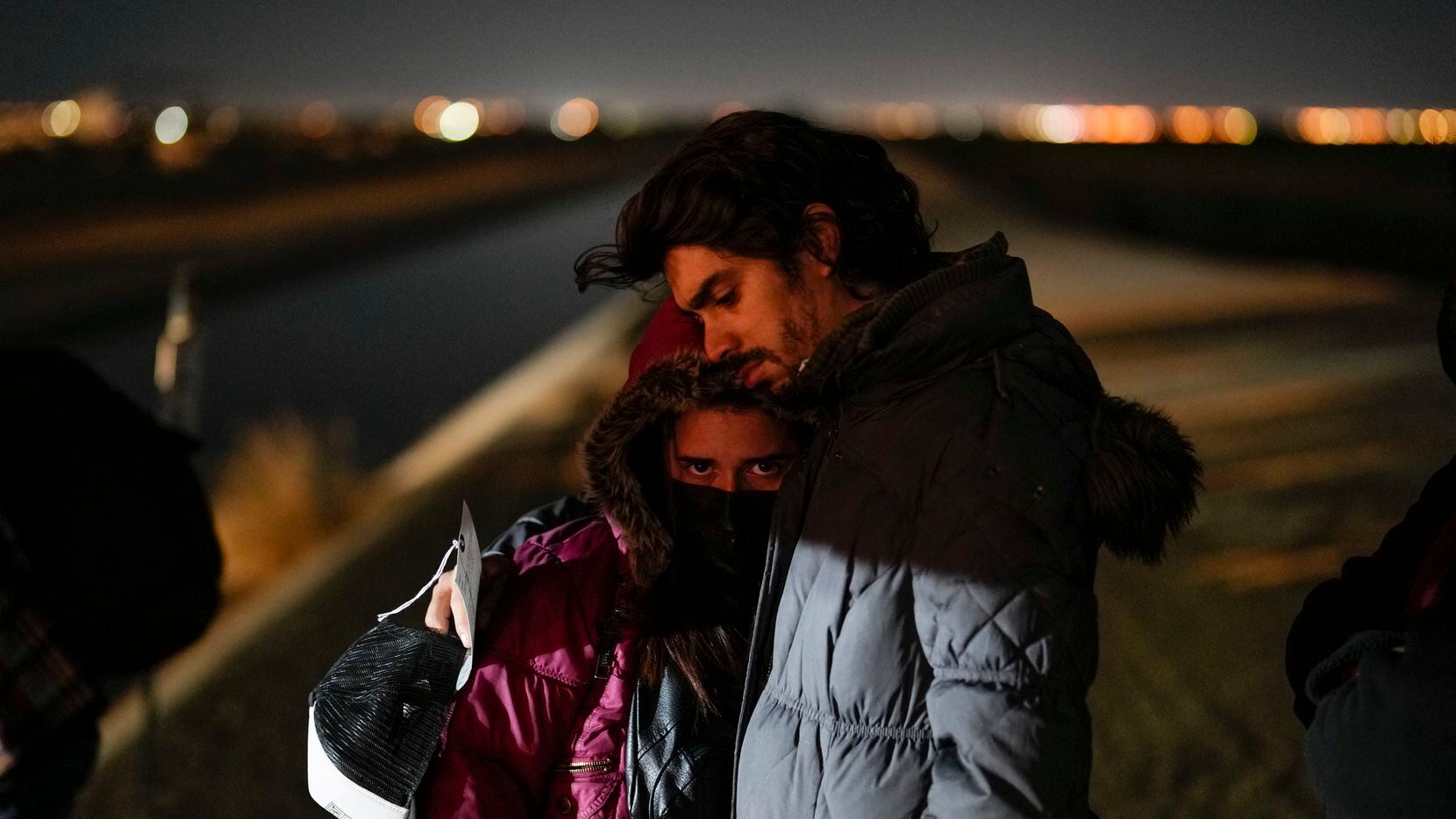 FILE - Cuban migrant Mario Perez holds his wife as they wait to be processed to seek asylum...