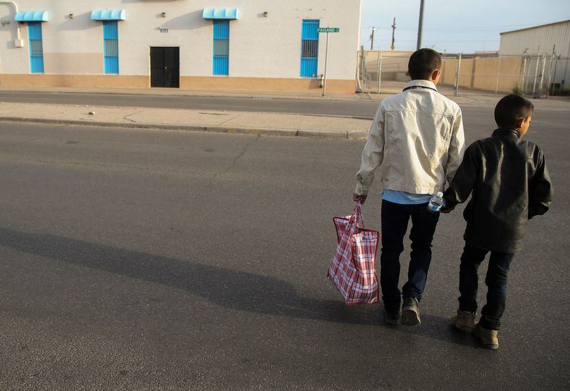 Carlos Joaquin Salinas, 27, of Santa Rosa, Guatamala, crosses the street with his son...