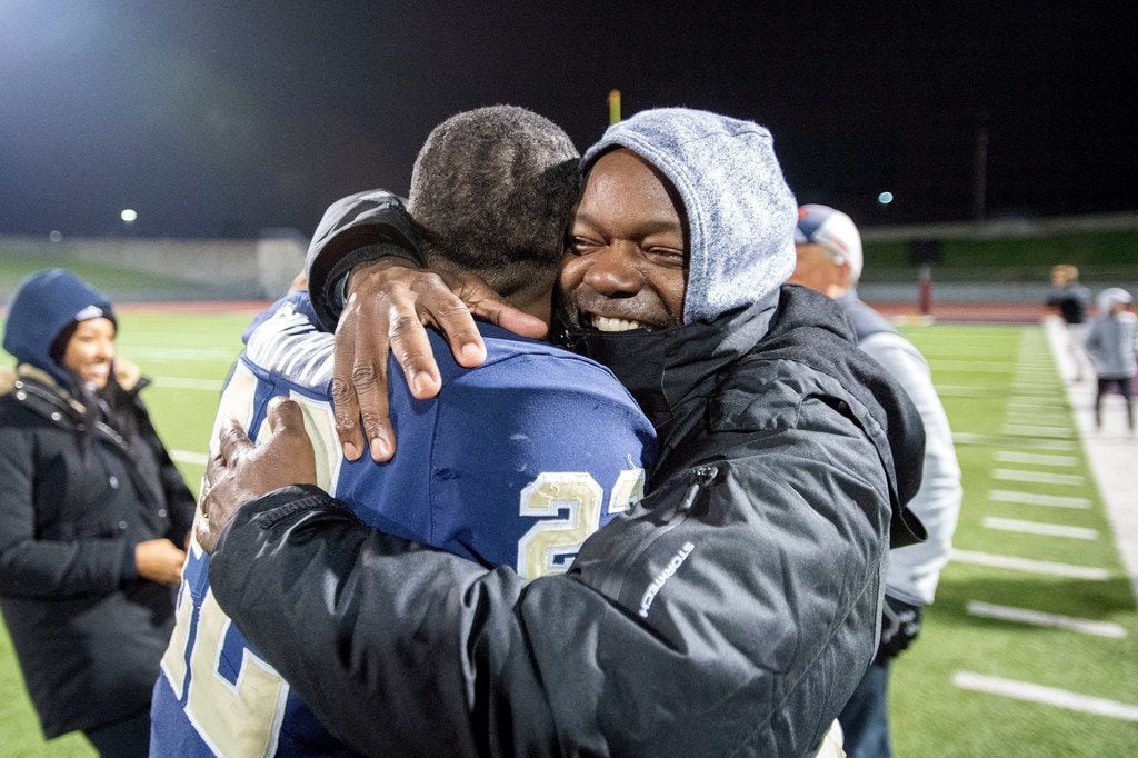 Jesuit senior running back E.J. Smith (22) gets a congratulatory hug from his father, NFL...