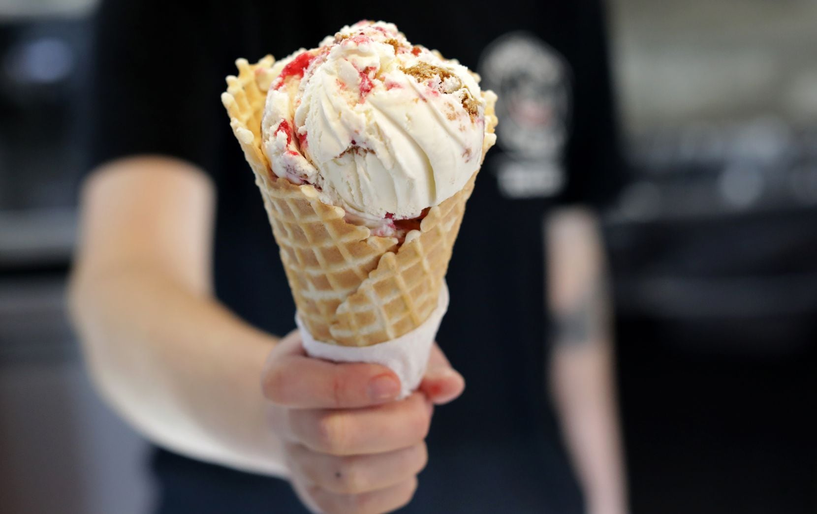 Josie McGillem holds a cranberry orange gingerbread cheesecake ice cream cone at Tongue in...