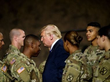 El presidente Donald Trump pasa junto a varios solados en Fort Drum, Nueva York, el 13 de agosto de 2019.