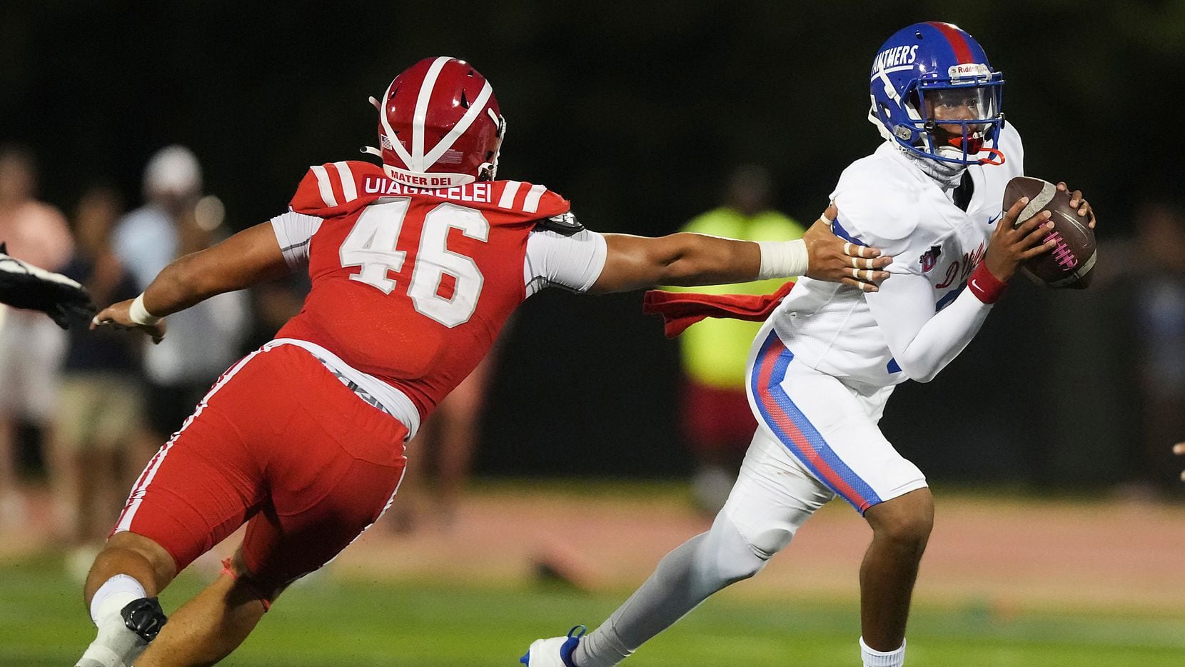 Duncanville quarterback Solomon James (3) slips away from Mater Dei defensive lineman Ta'i Ta'i Uiagalelei (46) during the first half of a high school football game on Friday, Aug. 27, 2021, in Duncanville.