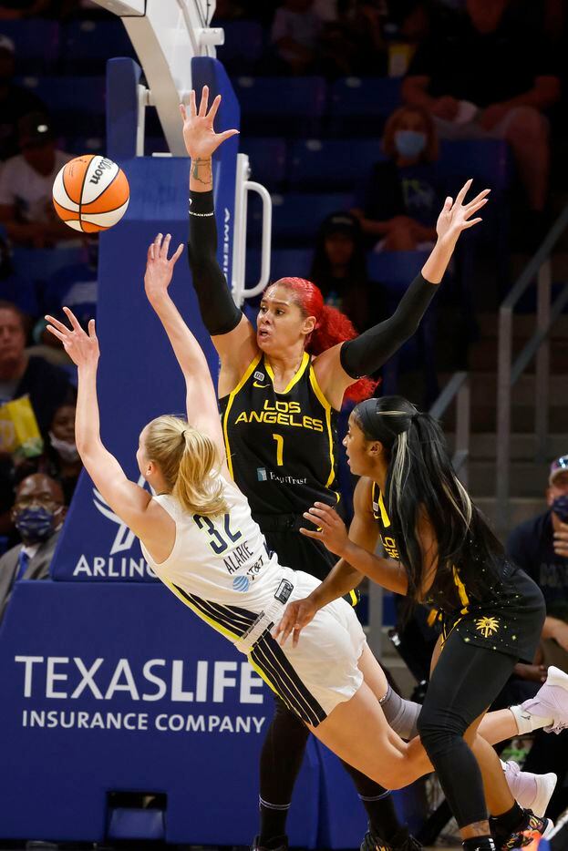 Dallas Wings center/forward Bella Alarie (32) gets a shot off as she is fouled by Los Angeles Sparks center Amanda Zahui B (1) and defended by Los Angeles Sparks guard Te'a Cooper, right, during the first half of a WNBA basketball game in Arlington, Texas on Sunday, Sept. 19, 2021. (Michael Ainsworth/Special Contributor)