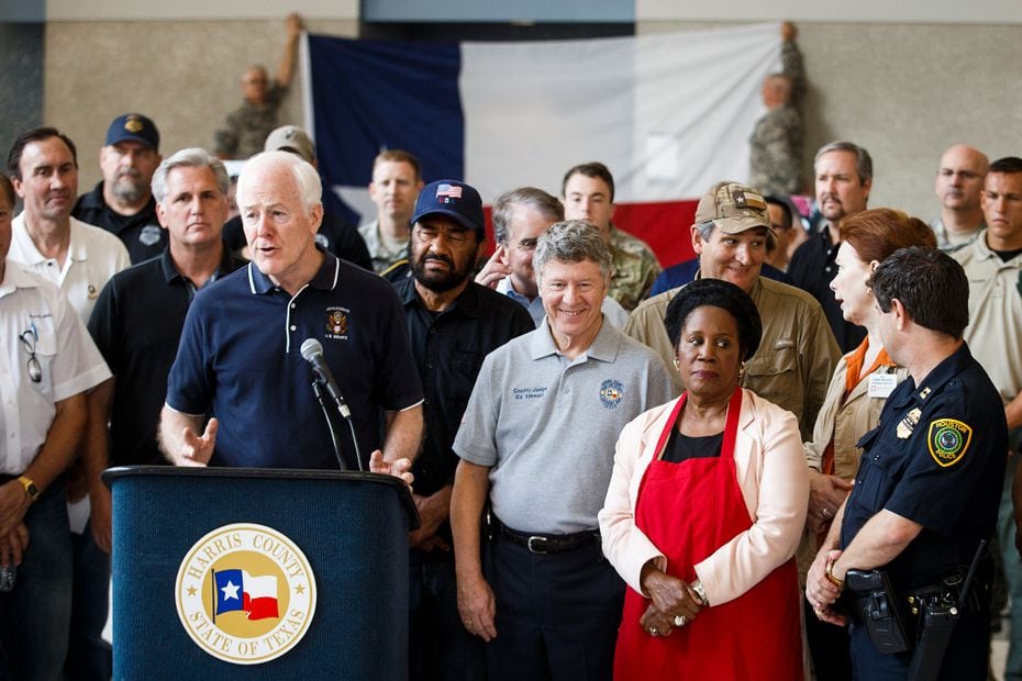 In this file photo, Sen. John Cornyn is surrounded by fellow lawmakers and law enforcement...