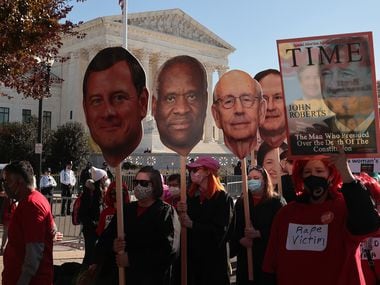 Demonstrators carry photo cut-outs of Supreme Court justices during arguments in Dobbs v. Jackson Women's Health, a case about a Mississippi law that bans most abortions after 15 weeks, on Dec. 1, 2021.