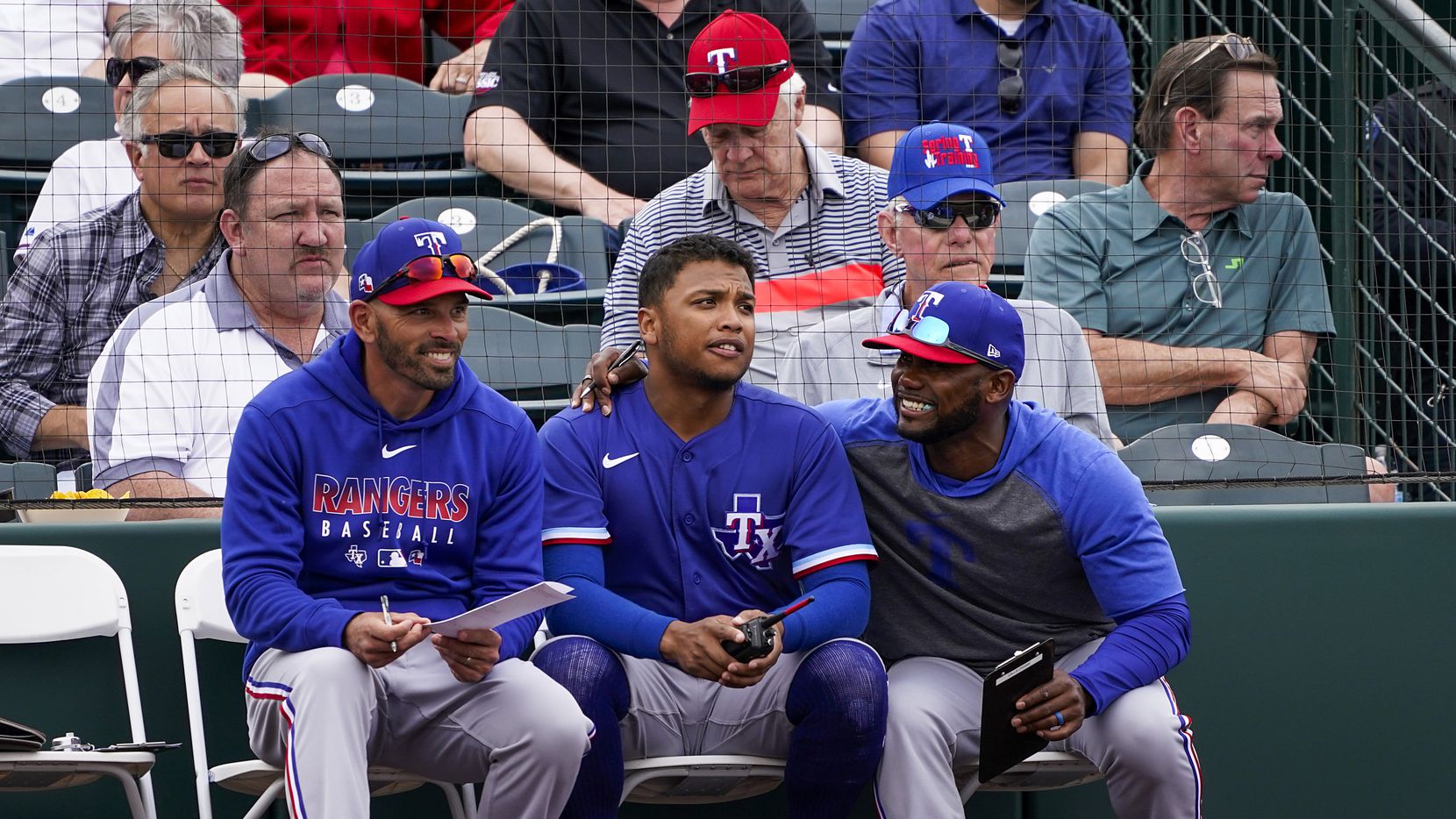 Texas Rangers outfielder Willie Calhoun (center) talks with assistant hitting coach Callix...