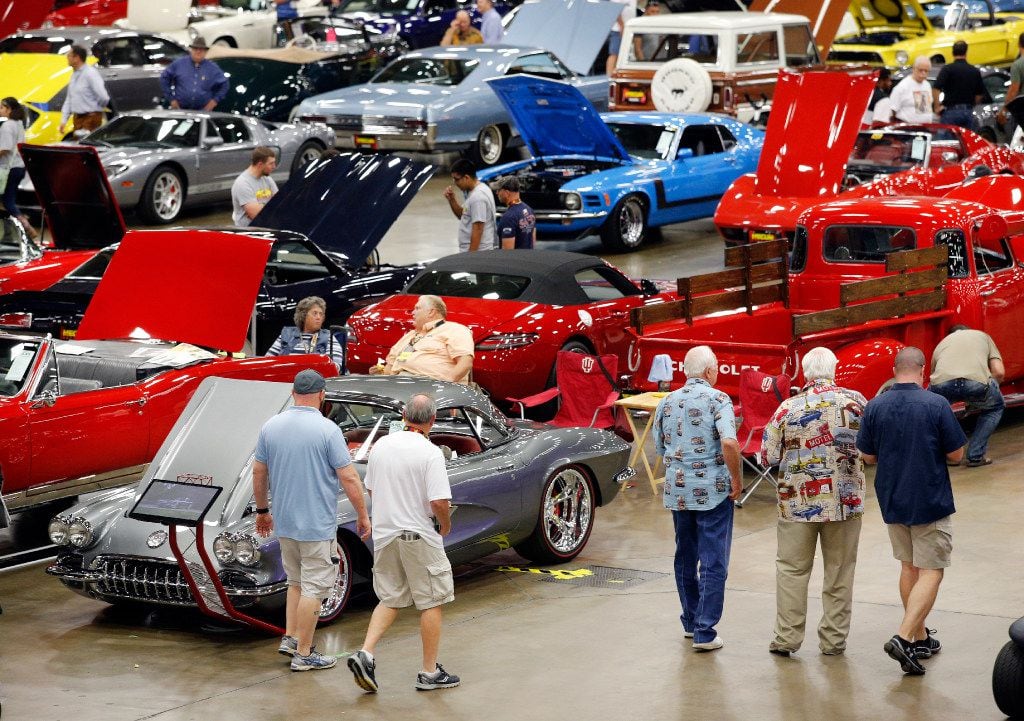 Car and truck enthusiasts walk the auction floor during the Mecum  Auto Auction show and...