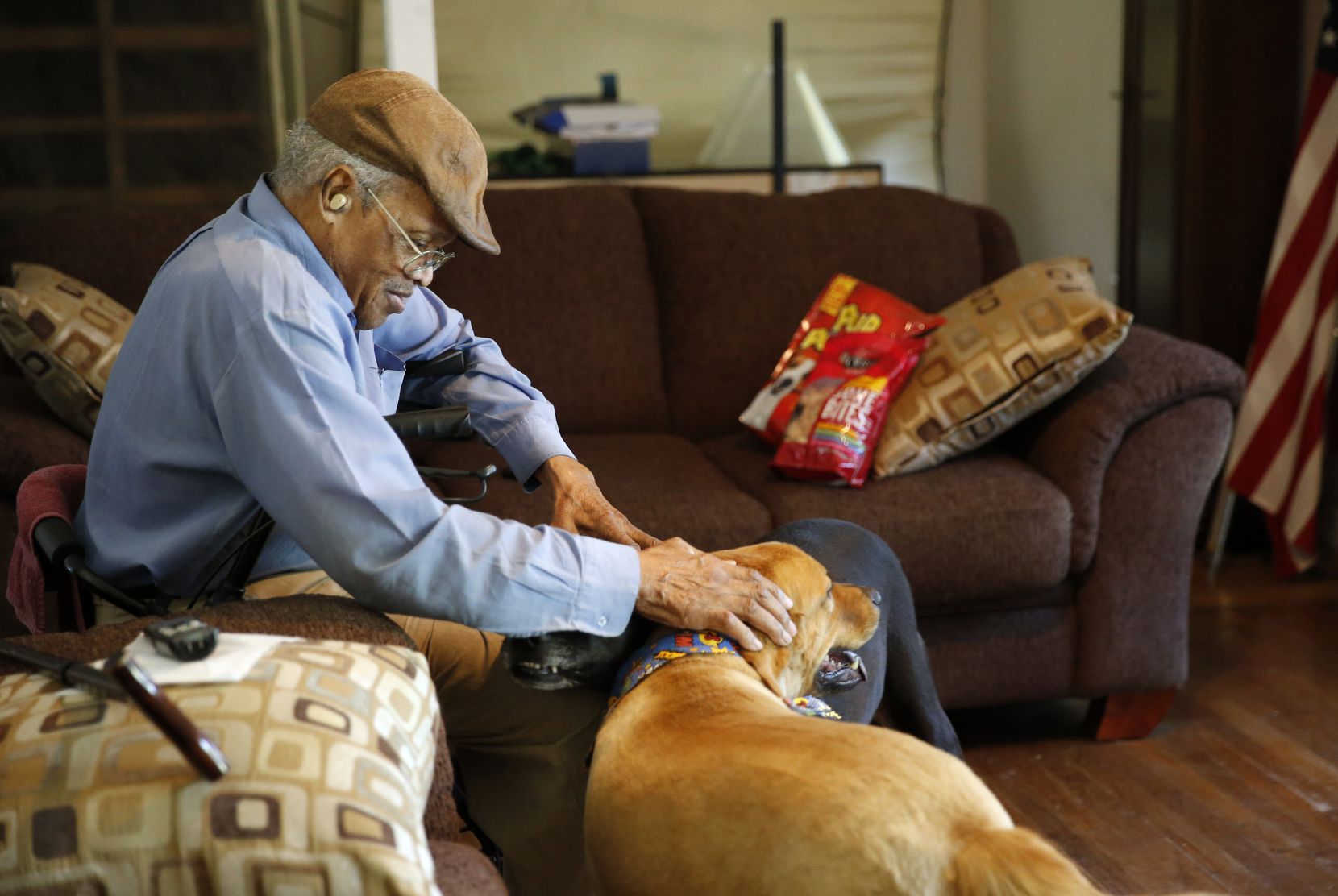 James Evans, 83 pets his dogs Rex (left) and Renny (right) at his home in Dallas, on...