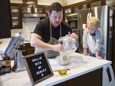 Chef Joe Baker, of Joe the Baker, and his son, Blais Baker, 5, who is dressed as a shark, host an online baking tutorial using Facebook Live from their kitchen on Friday, March 20, 2020 in Coppell. The Baker family, just like many others, is practicing social distancing due to the spread of coronavirus. Blais wears a different costume in every episode and they start with a joke. (Ashley Landis/The Dallas Morning News)