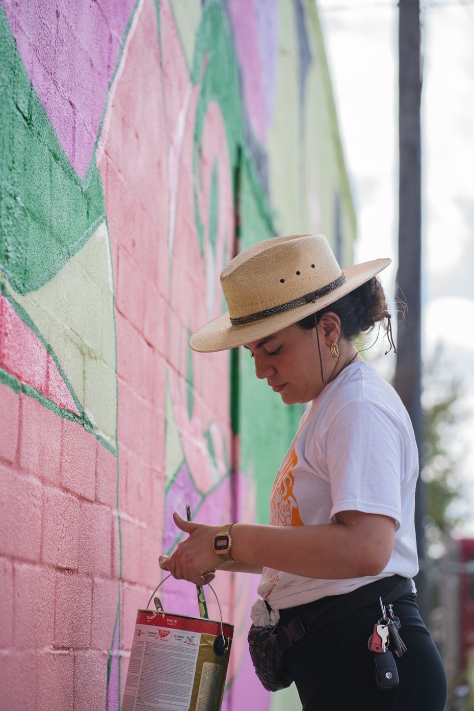 Artist Stephanie Sanz paints a mural of two women embracing for the Wild West Mural Fest. (Photo by Jeremy Biggers, courtesy of Wild West Mural Fest)