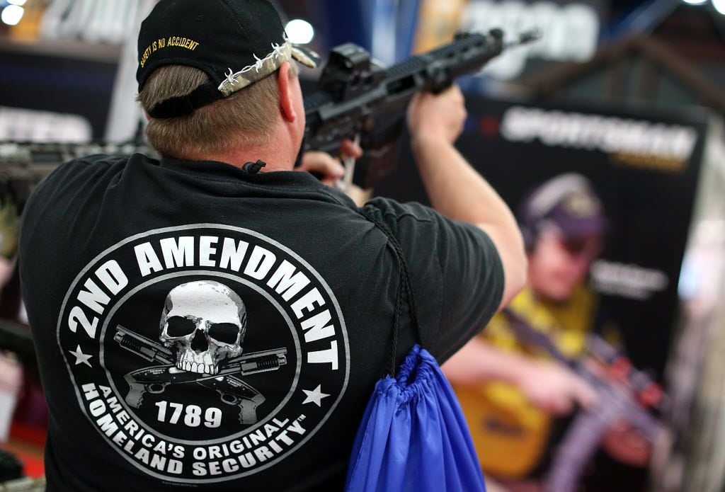 An attendee inspectss an assault rifle during the 2013 NRA Annual Meeting and Exhibits at...