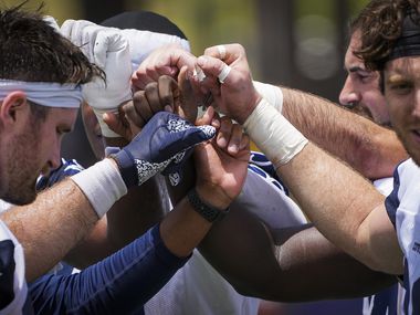 Dallas Cowboys tight end Dalton Schultz (left) and tight end Blake Jarwin (right) join their teammates as they gather after the team's first training camp practice on Thursday July 22, 2021 in Oxnard, California. 
