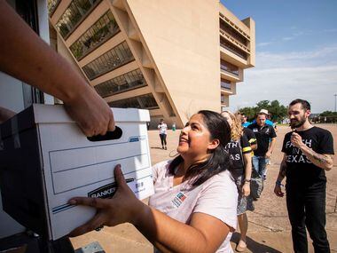 Diana Ramirez, of the Workers Defense Project, helps unload a truckload of boxes as a...