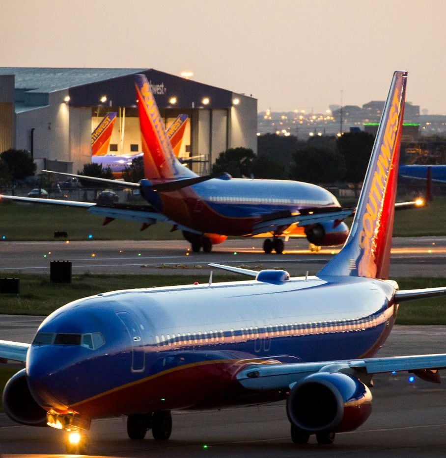 Southwest Airlines 737 planes taxi in opposite directions near a maintenance hangar at Love...
