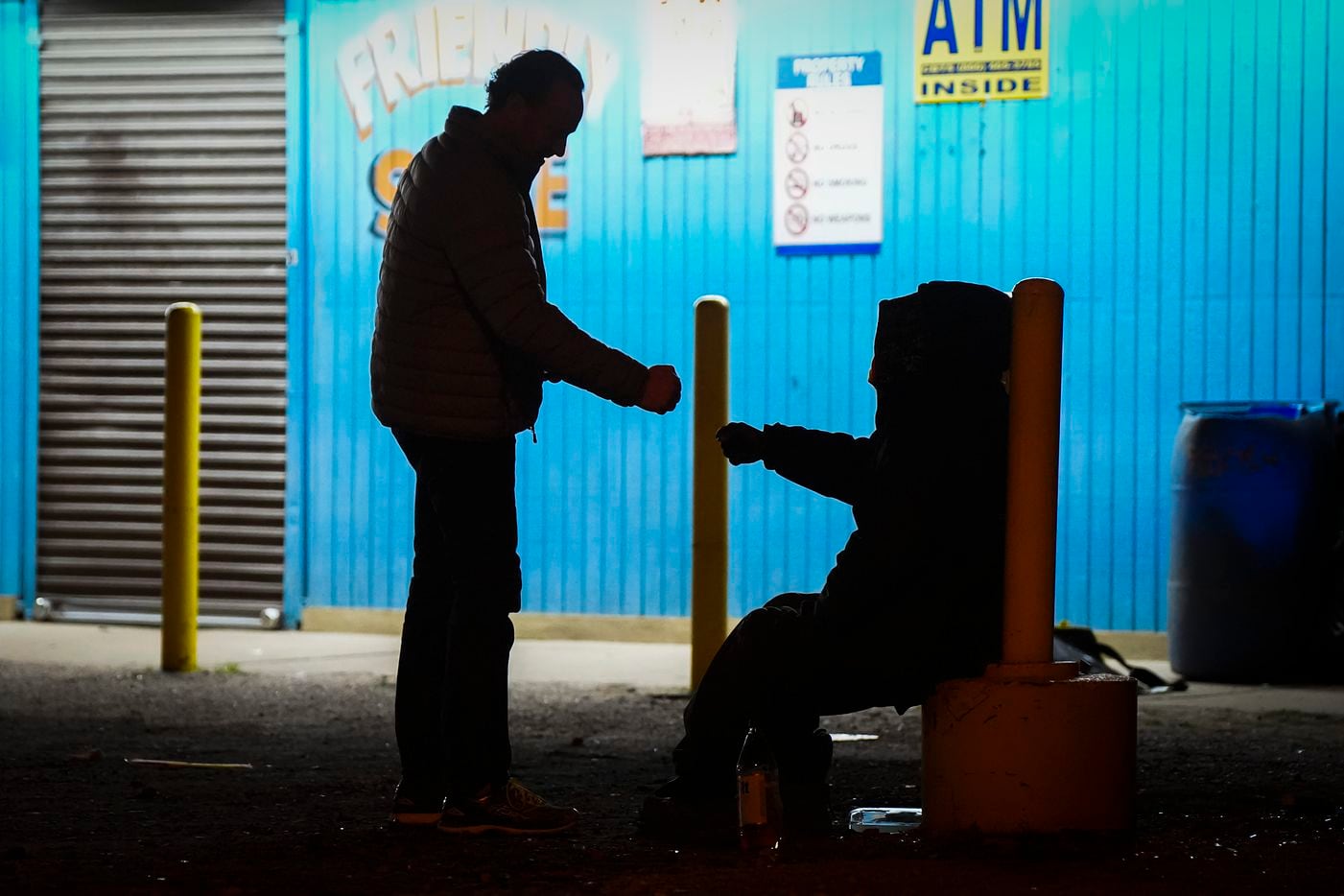Housing Forward chair Peter Brodsky fist bumps a man experiencing homelessness before...