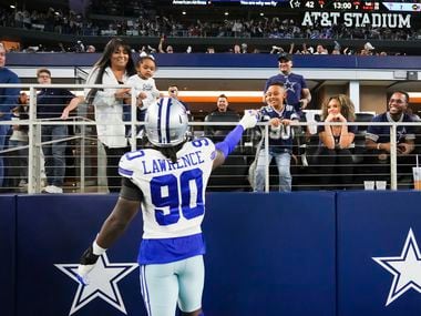 Dallas Cowboys defensive end Demarcus Lawrence (90) celebrates with his family as he leaves the field at halftime of an NFL football game against the Washington Football Team at AT&T Stadium on Sunday, Dec. 26, 2021, in Arlington.
