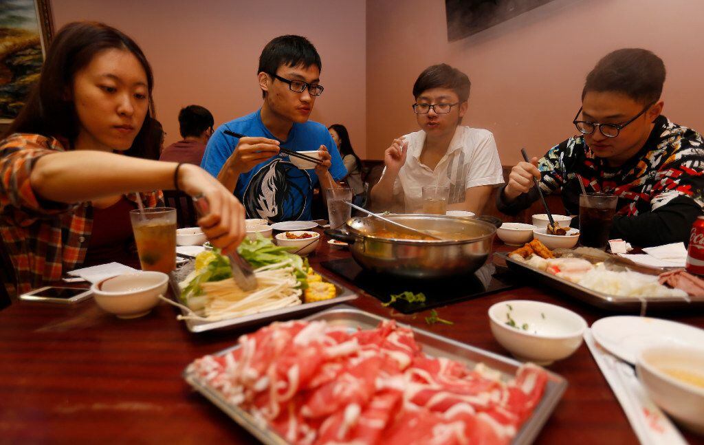 From left: Jessica Zeng; Daniel Xu; Ricky Yang and Zhongyu Liu dine on the hot pot side of...