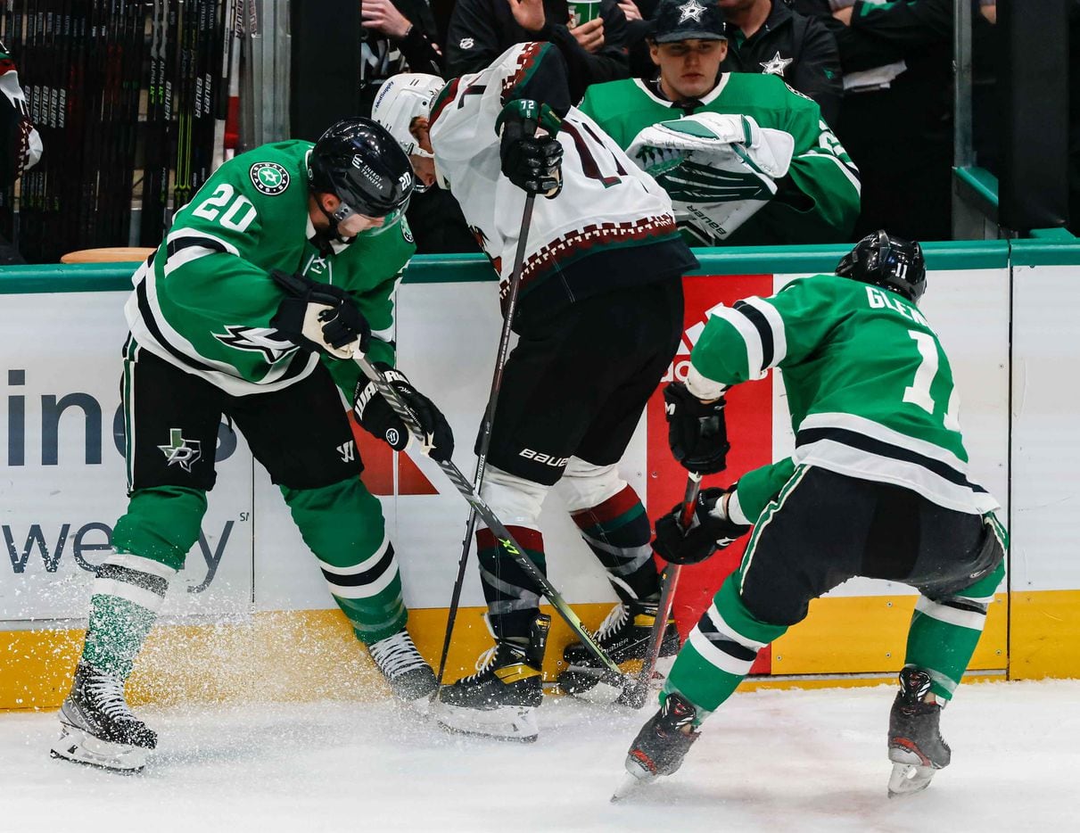 Dallas Stars defenseman Ryan Suter (20), center Luke Glendening (11) and Arizona Coyotes center Travis Boyd (72) try to take control of the puck during second period at the American Airlines Center in Dallas on Monday, December 6, 2021. (Lola Gomez/The Dallas Morning News)