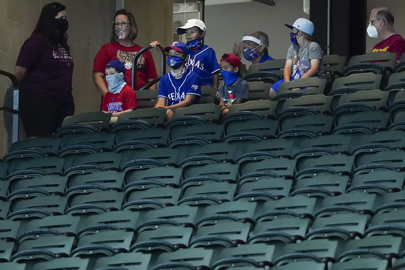 A stadium tour group pauses to watch a game between players at the Texas Rangers alternate...
