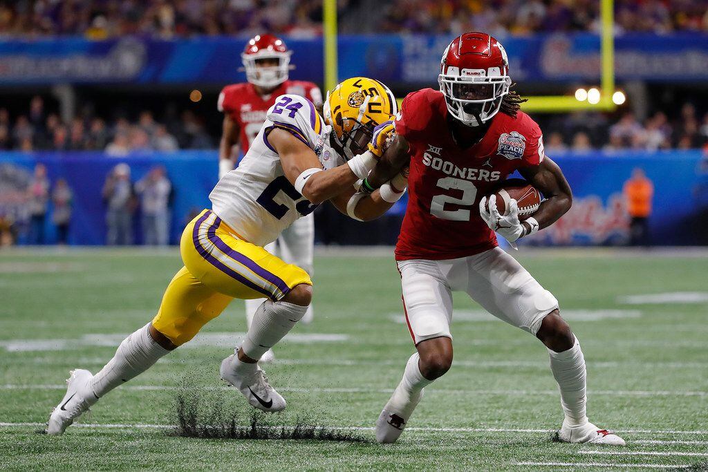 ATLANTA, GEORGIA - DECEMBER 28: Wide receiver CeeDee Lamb #2 of the Oklahoma Sooners carries the ball against Chris Curry #24 of the LSU Tigers during the Chick-fil-A Peach Bowl at Mercedes-Benz Stadium on December 28, 2019 in Atlanta, Georgia. (Photo by Kevin C. Cox/Getty Images)