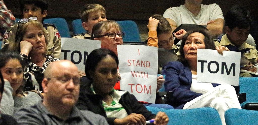 Supporters of councilman Tom Harrison hold signs in the audience as the Plano City Council...