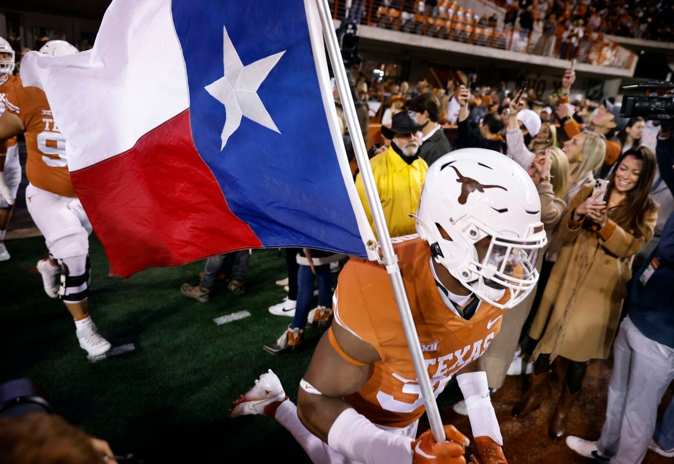 Texas Longhorns linebacker Devin Richardson (30) carries the Texas flag as the team takes...