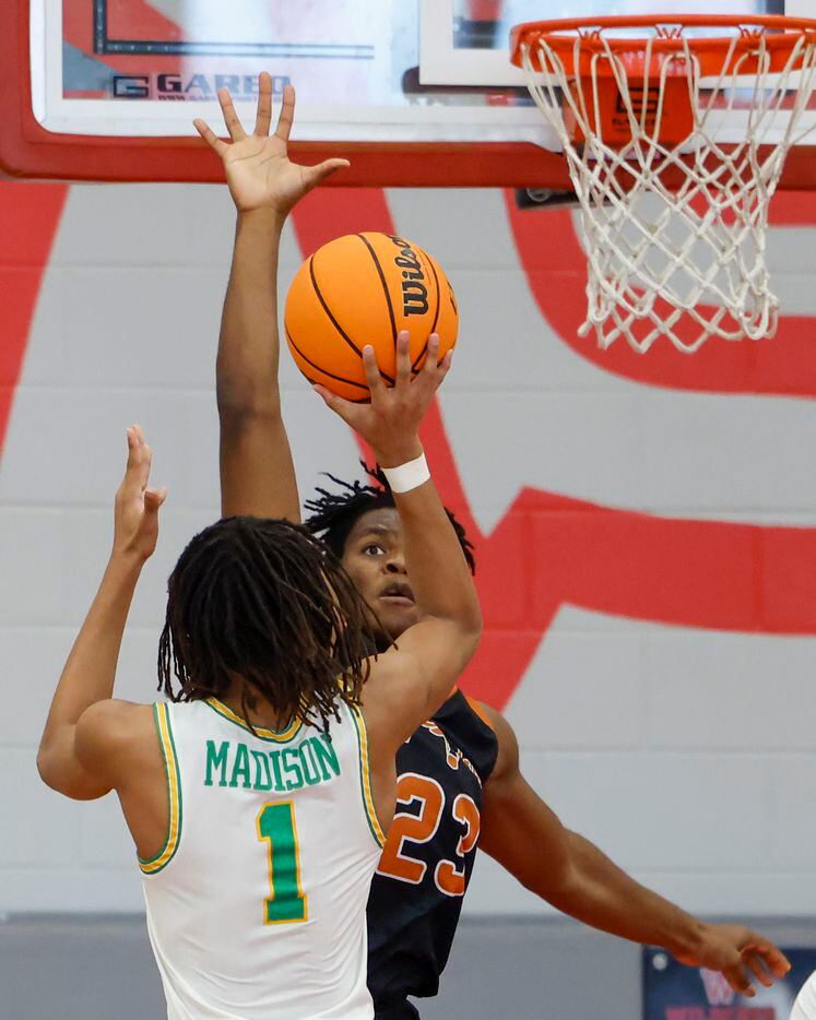 W.T. White forward PJ Washington (23) attempts to block the shot of Madison guard Pierre Hunter II (1) during the first quarter of a Dallas ISD Holiday Invitational basketball tournament game at Woodrow Wilson High School in Dallas, Tuesday, Dec. 28, 2021.