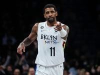 Brooklyn Nets' Kyrie Irving gestures to a teammate during the first half of the team's NBA...