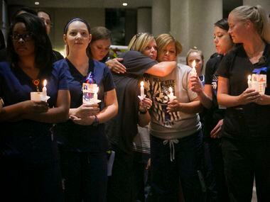 Baylor University Medical Center employees gather outside the emergency room during a vigil...