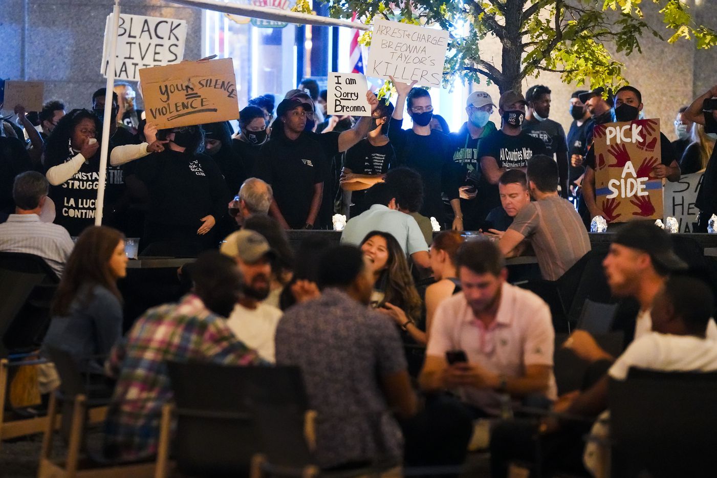 Protesters shout at people dining on the patio at Jaxon Beer Garden in AT&T Discovery District in downtown Dallas after a Kentucky grand jury brought no charges against Louisville police for the killing of Breonna Taylor on Wednesday, Sept. 23, 2020.