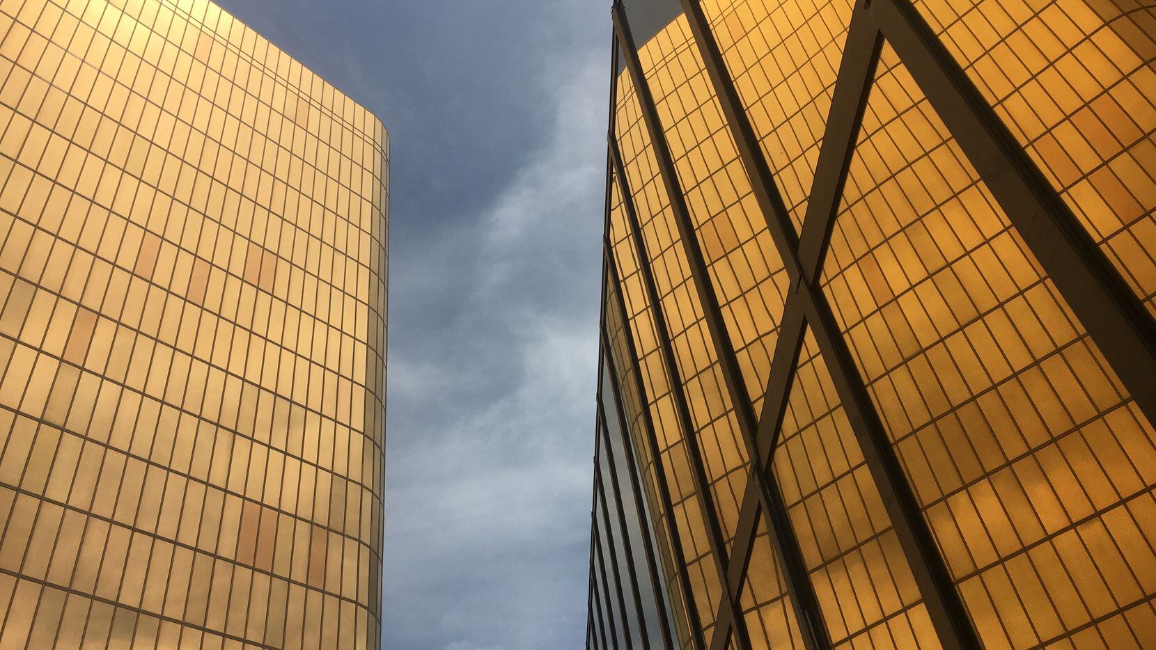 The golden facades of the Campbell Centre, the landmark glowing ingots, reflected in...