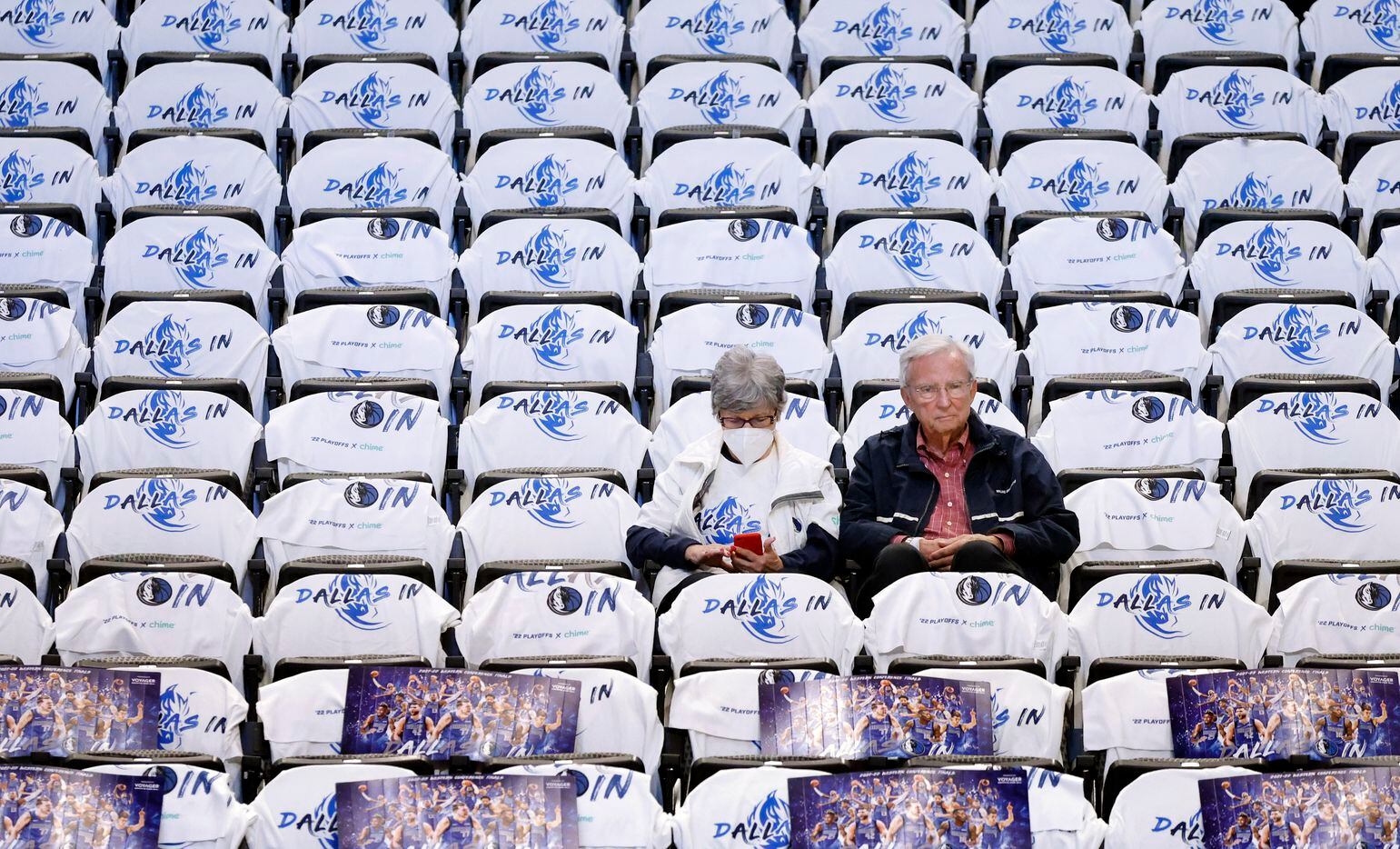 Dallas Mavericks fans arrive early to find their seats covered in white t-shirts before the...