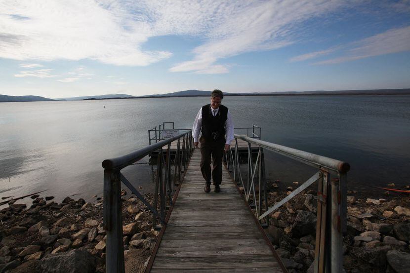 Stephen Greetham, the lawyer for the Chickasaw nation, walks up a pier on Sardis Lake, near...