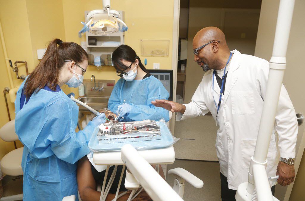 Dentist Dwayne Evans (right) reassures patient Thelma Chappell as she gets work done by...