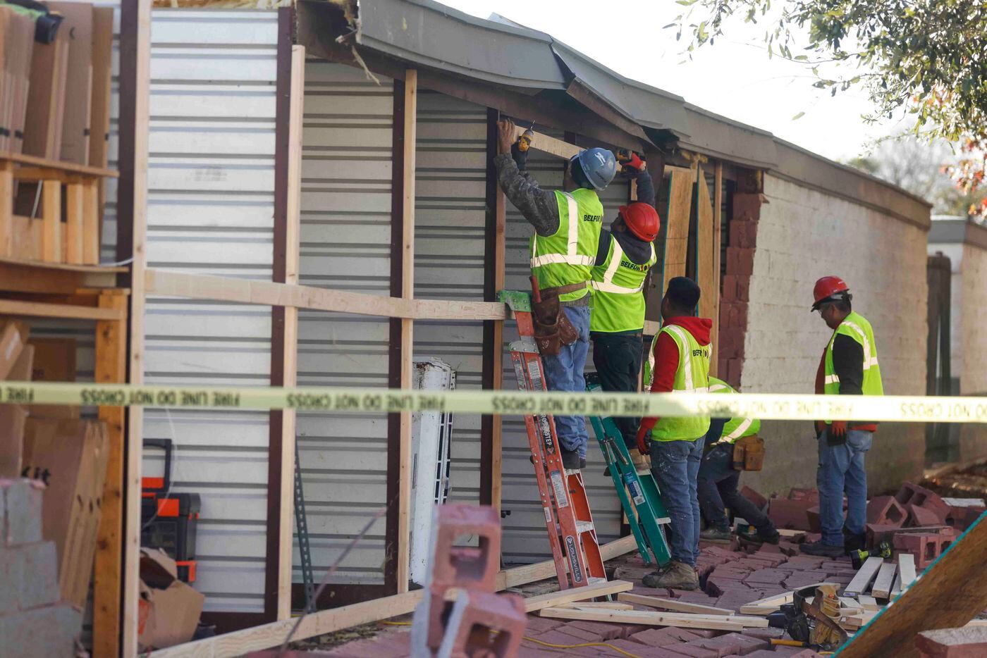 Crews work as they board up damaged openings at Extra Space Storage in Grapevine on...