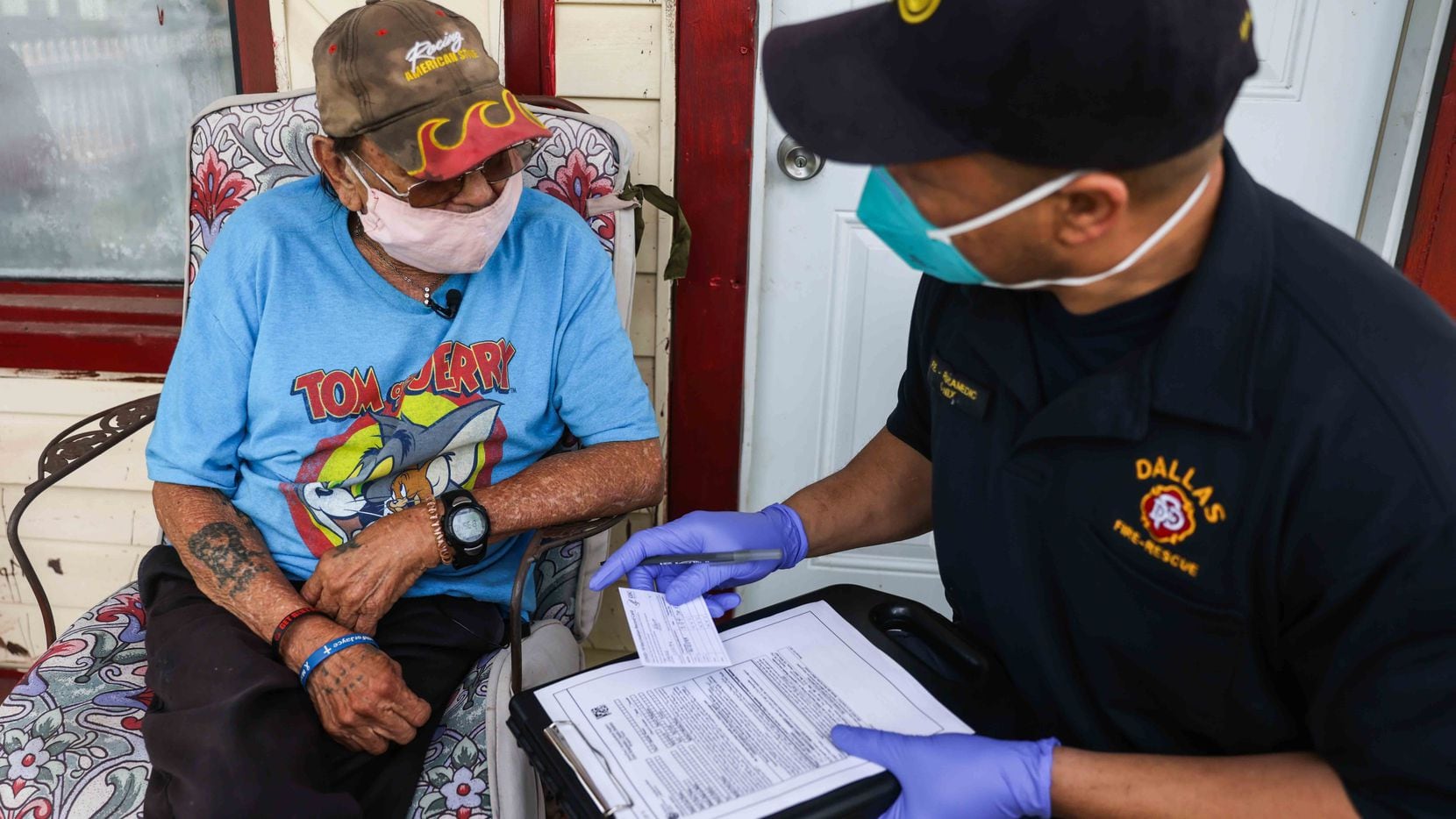Dallas Fire-Rescue officer Corey Nix gave Albert Garza, 75, his vaccine card after Garza...