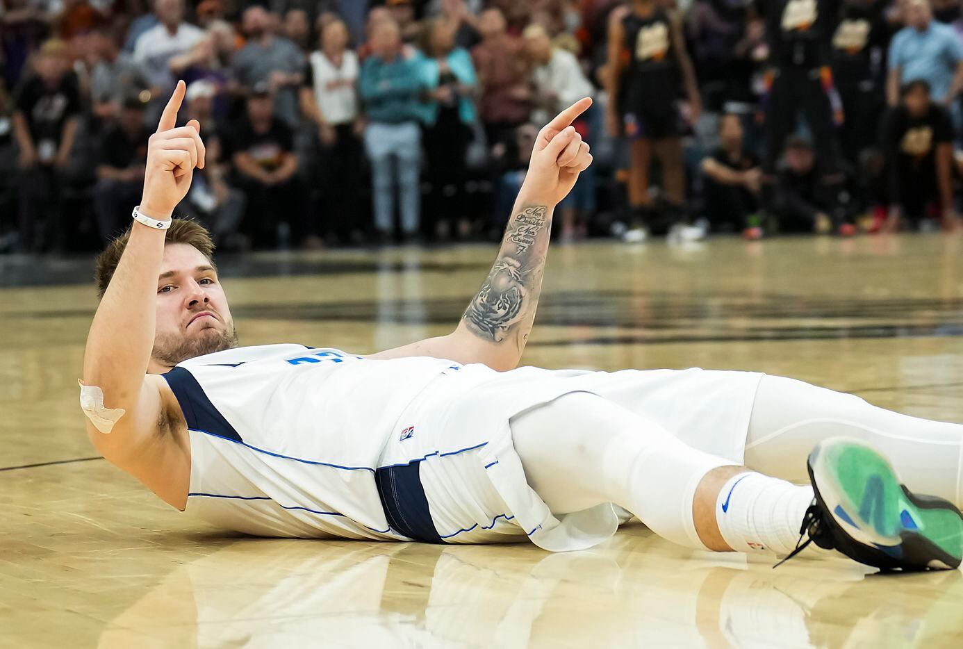 Dallas Mavericks guard Luka Doncic reacts after being knocked to the floor on a foul during...