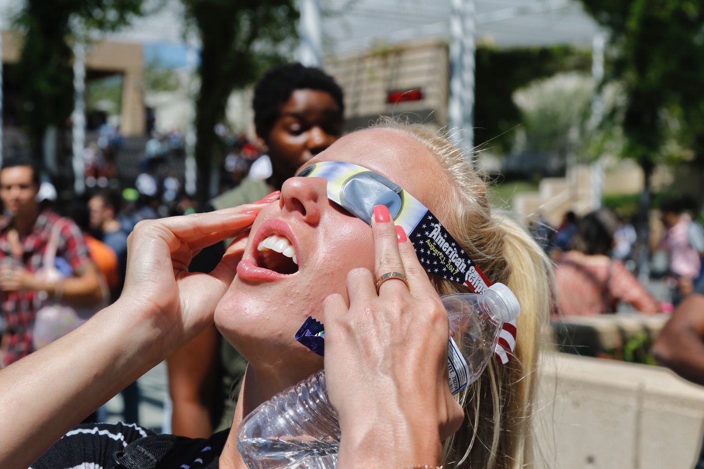 University of Texas at Dallas student Ashton Murray reacts as she views the solar eclipse through borrowed eclipse glasses. She was one of hundreds of students and faculty who stopped by the McDermott Library eclipse party.
