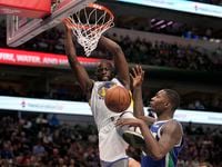 Golden State Warriors forward Draymond Green dunks the ball over Dallas Mavericks forward...