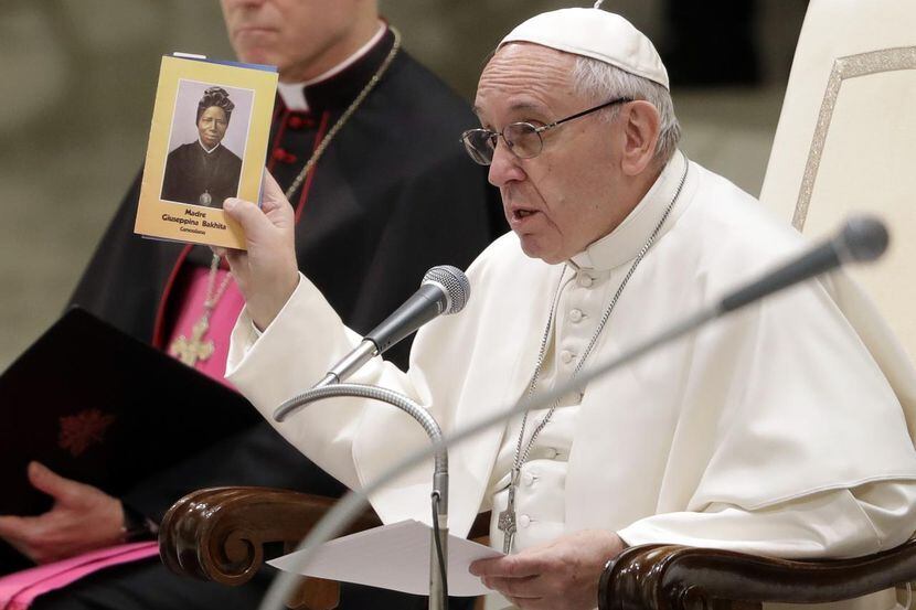 El papa Francisco alza un retrato de la santa sudanesa Josephine Bakhita en su audiencia...