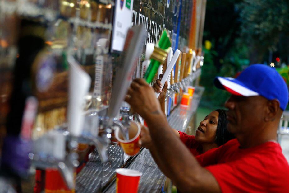 Donna Rubio (left) and Pepe Sanchez pull beers at the Beer Haven under the ferris wheel...